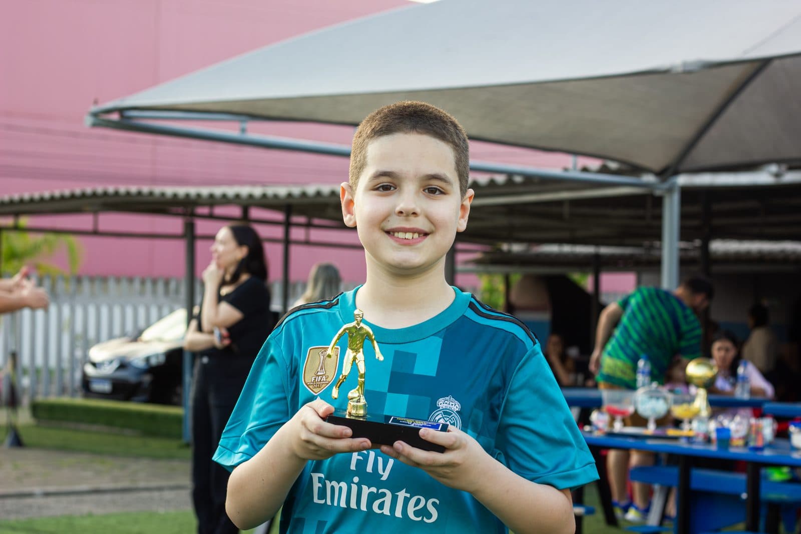 Aniversariante sorrindo com o troféu